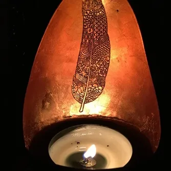 lit feather bronze candle